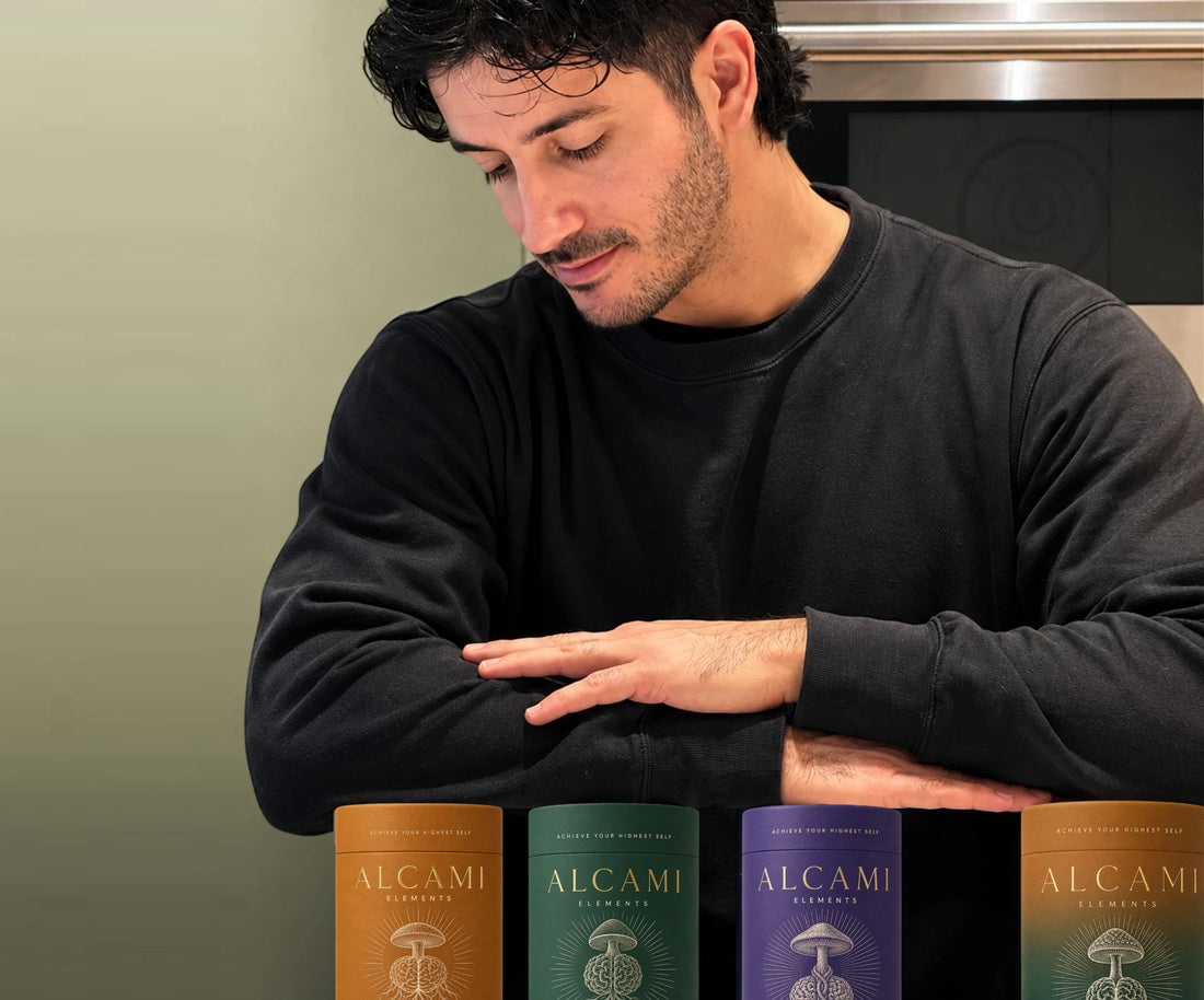 Man resting his arms on a counter above the three Alcami Smart Tea canisters
